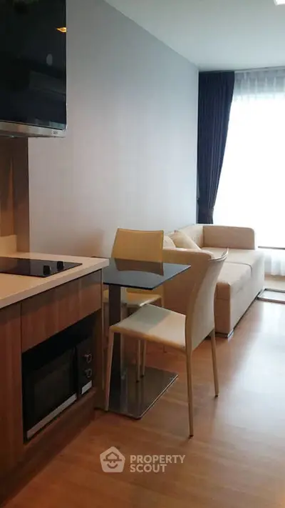 Modern living room with cozy sofa and dining area in open layout apartment.