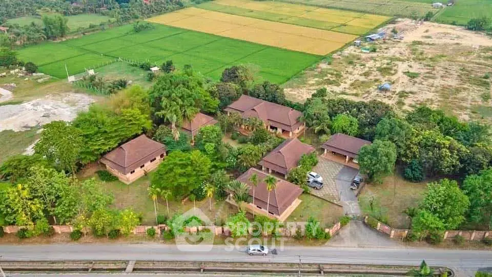 Aerial view of countryside property with multiple houses and lush greenery.