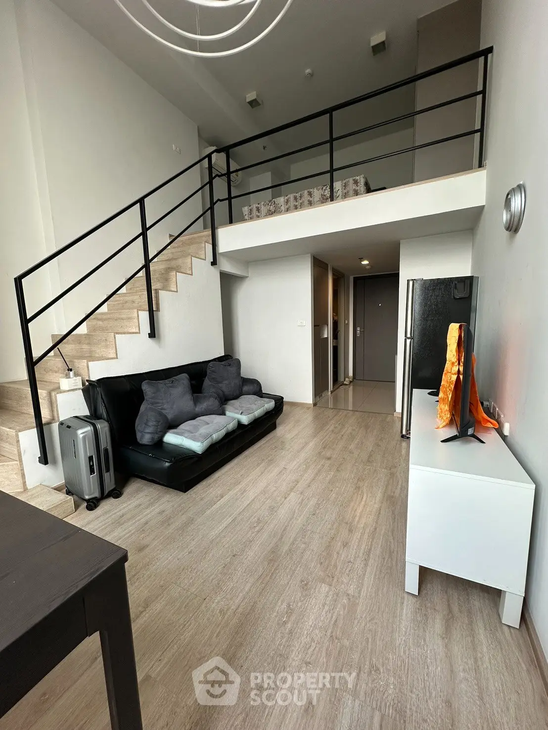 Modern loft apartment with mezzanine, sleek staircase, and stylish living area.