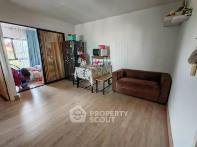 Spacious living room with wooden flooring and cozy brown sofa