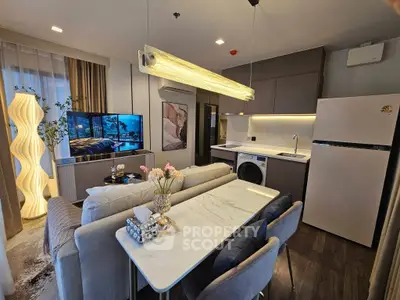Modern open-plan living room with stylish decor, featuring a cozy seating area, dining table, and integrated kitchen appliances.