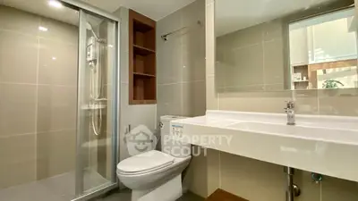 Modern bathroom with glass shower and sleek fixtures in a contemporary home.