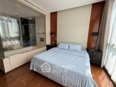 Luxurious bedroom with modern design and glass-walled ensuite bathroom in high-end apartment.