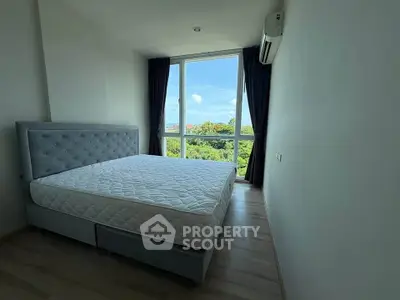 Bright bedroom with large window offering scenic views, featuring a comfortable bed and modern air conditioning.