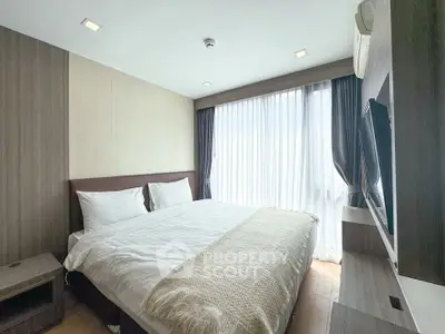 Modern bedroom with large window and stylish decor in a cozy apartment.