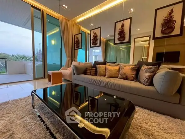Luxurious living room with modern decor and large glass doors opening to a balcony.