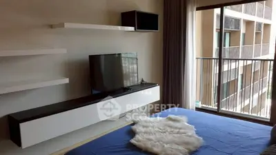 Modern bedroom with TV and balcony view in stylish apartment