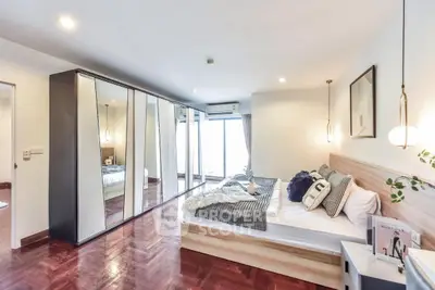 Spacious modern bedroom with elegant decor and large mirrored wardrobe