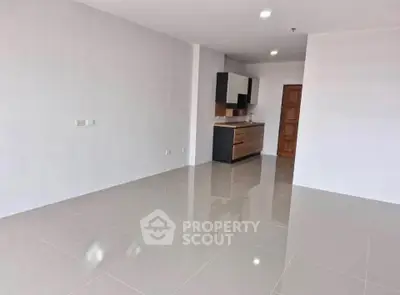Spacious modern apartment with sleek kitchen and glossy tiled floors.