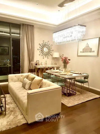 Luxurious living room with elegant chandelier and plush sofa in modern apartment.