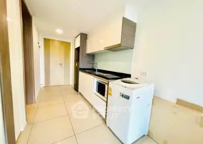 Modern kitchen with sleek cabinetry and compact appliances in a bright apartment.
