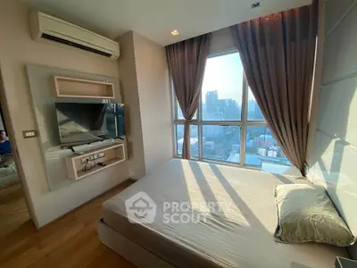 Modern bedroom with large window offering stunning city views, featuring sleek design and natural light.