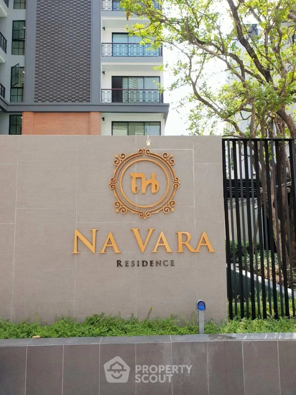 Modern residential building with Na Vara Residence sign and lush greenery.