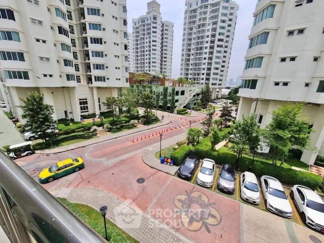 Stunning view of modern residential complex with lush greenery and ample parking space.