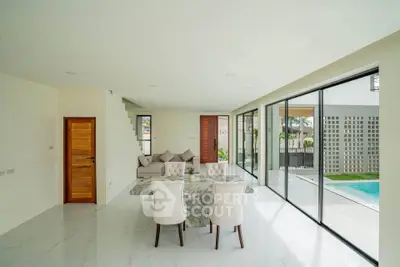 Luxurious open-plan living room with marble dining table and pool view