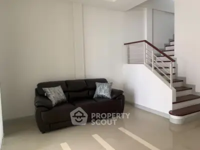 Modern living room with sleek staircase and stylish sofa