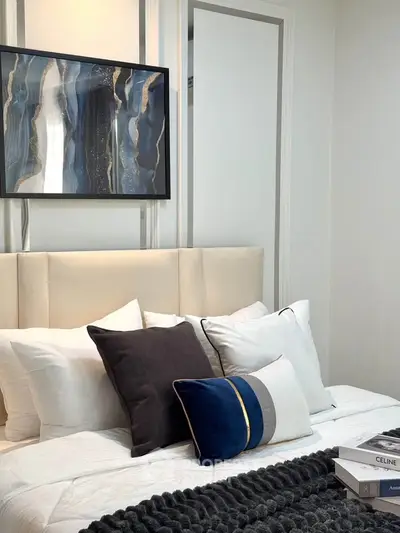 Elegant bedroom with modern art and plush pillows, perfect for relaxation.