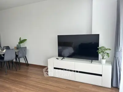 Modern living room with sleek TV stand and dining area, featuring elegant decor and natural light.