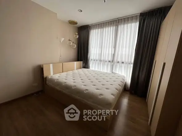 Spacious bedroom with large windows and modern furnishings.