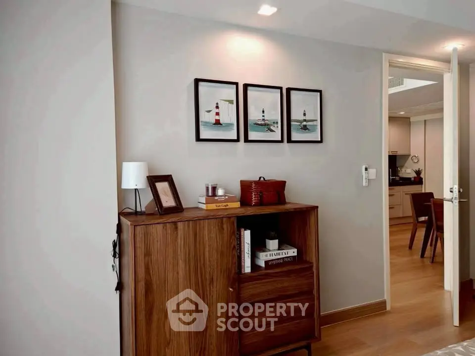 Stylish interior with wooden cabinet and lighthouse artwork in modern apartment