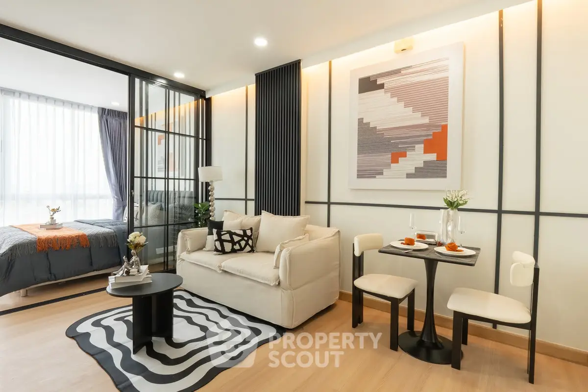 Modern living room with stylish decor and open layout leading to bedroom