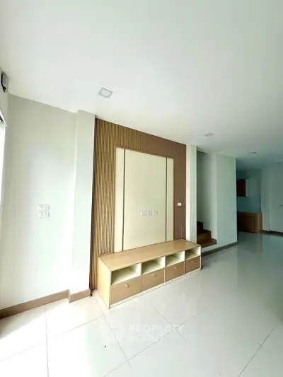 Modern minimalist living room with sleek storage unit and bright natural lighting.