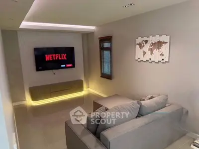 Modern living room with cozy gray sofa and wall-mounted TV, perfect for entertainment.