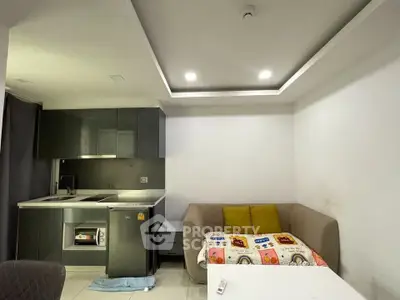 Modern compact kitchen and cozy living area with sleek cabinetry and comfortable seating.