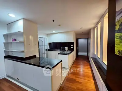 Modern kitchen with sleek black countertops and wooden flooring