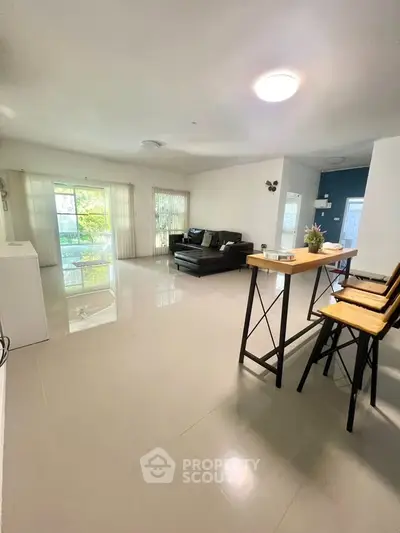 Spacious modern living room with sleek flooring and stylish furniture, perfect for entertaining.