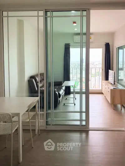 Modern apartment with glass sliding doors, spacious living area, and city view balcony.