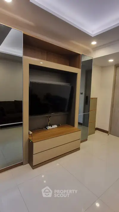 Modern living room with sleek TV unit and mirrored accents