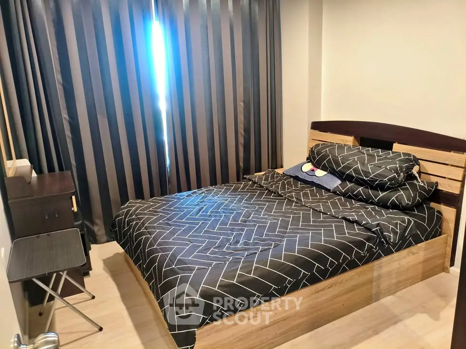 Cozy bedroom with modern decor and stylish bed linens in a well-lit apartment.