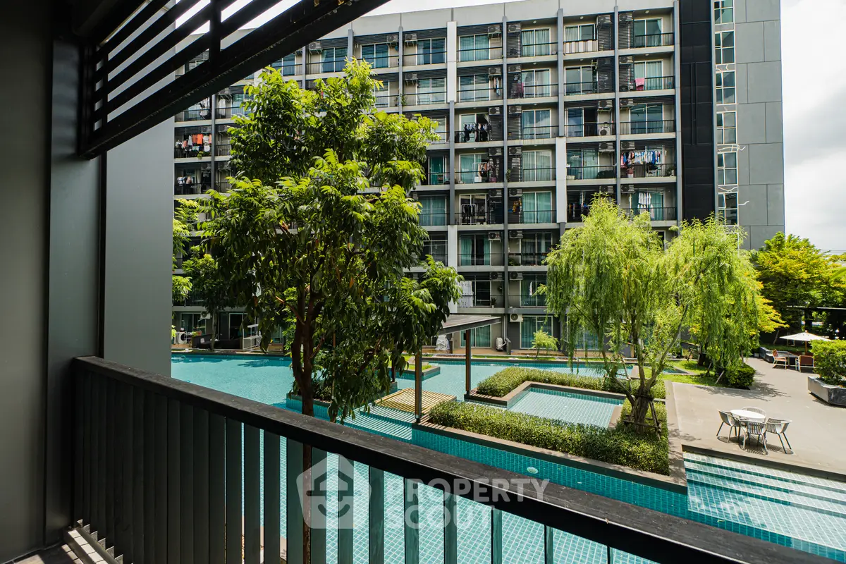 Modern apartment building with pool view and lush greenery