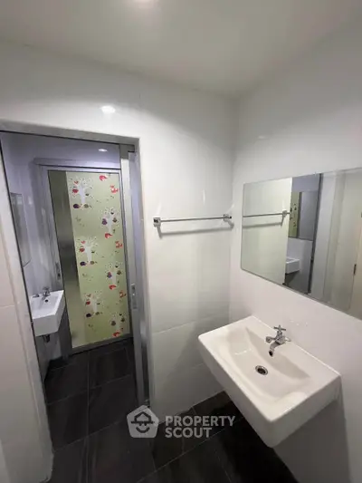 Modern bathroom with sleek sink and decorative glass door, perfect for contemporary living.