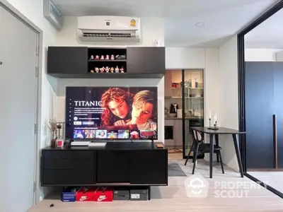 Modern living room with sleek black furniture and entertainment center, open layout to dining area.