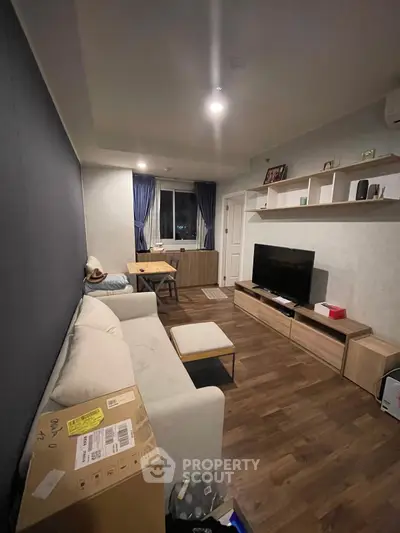 Modern living room with cozy sofa, TV unit, and stylish decor in a well-lit apartment.