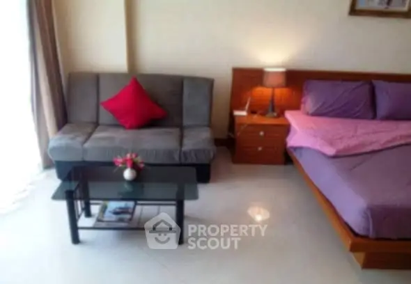 Cozy bedroom with modern decor and a small sitting area.