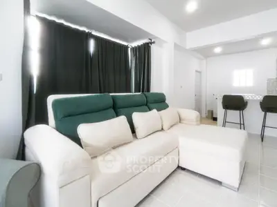 Modern living room with stylish sofa and bar stools in open layout.