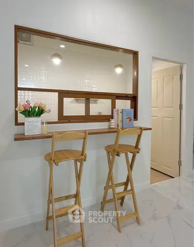 Charming kitchen with breakfast bar and wooden stools, perfect for cozy meals and modern living.