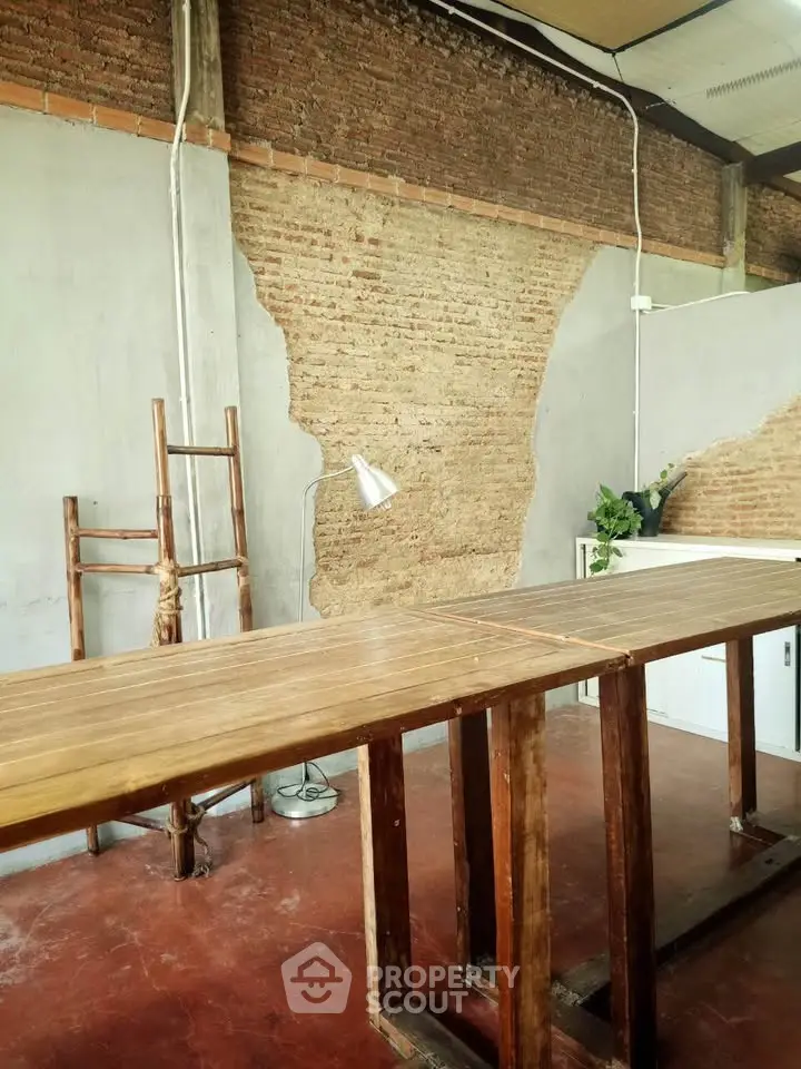 Industrial-style study room with exposed brick wall and wooden table.