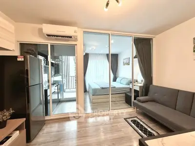 Modern studio apartment with glass partition, cozy living area, and stylish bedroom.