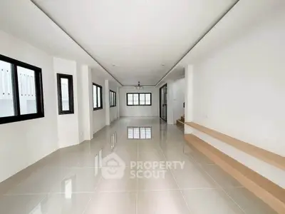 Spacious modern living room with large windows and sleek tile flooring