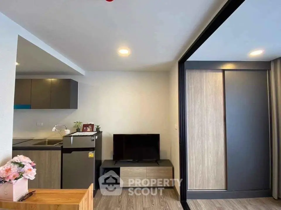 Modern living room with sleek kitchen and stylish decor in a contemporary apartment.