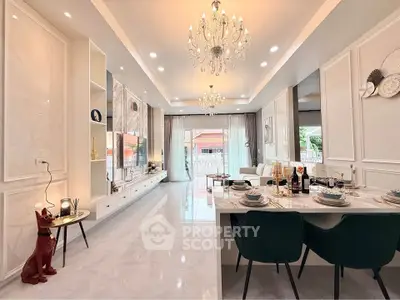 Luxurious open-plan living and dining area with elegant chandeliers and modern decor.