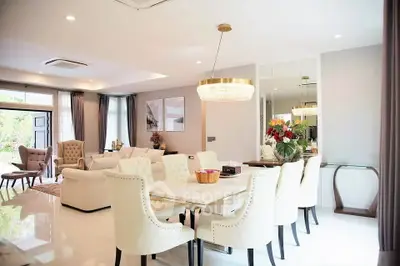 Luxurious open-plan living and dining area with elegant furnishings and modern lighting.