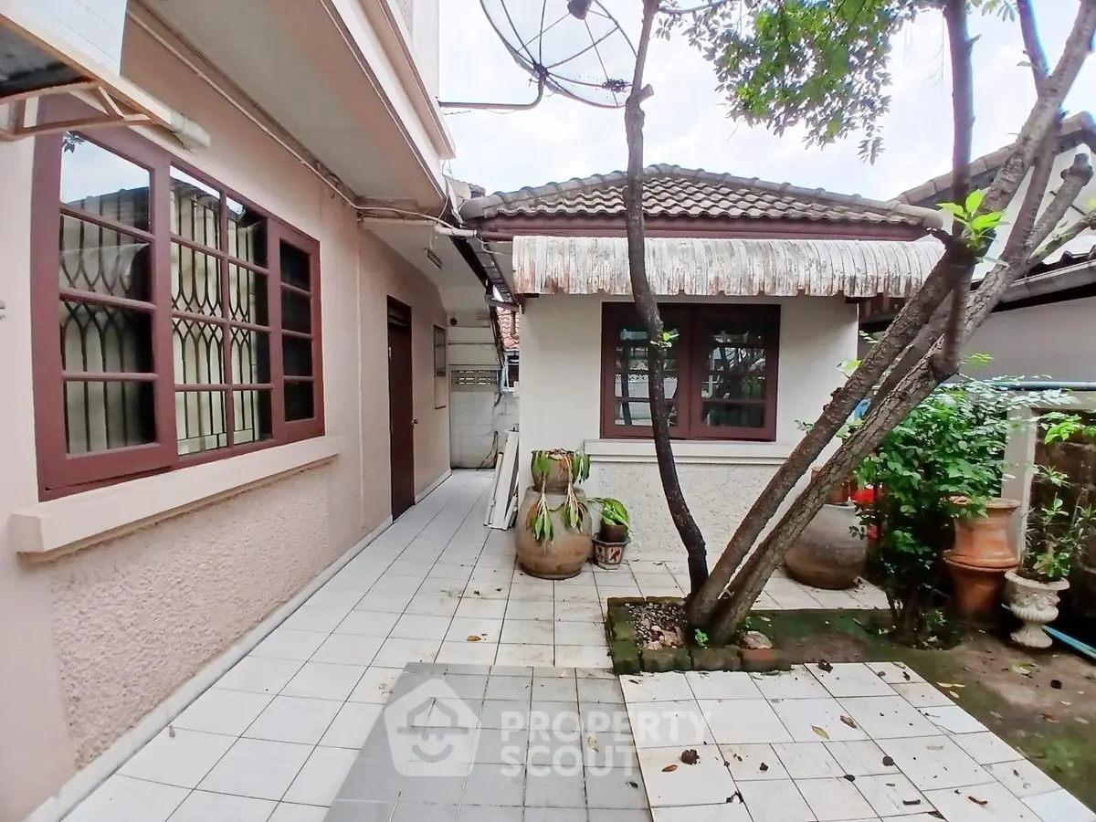 Charming exterior view of a cozy home with a tiled roof and lush garden.