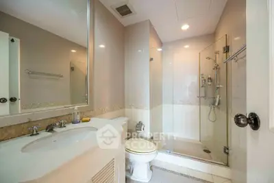 Modern bathroom with glass shower and elegant vanity in a stylish home.
