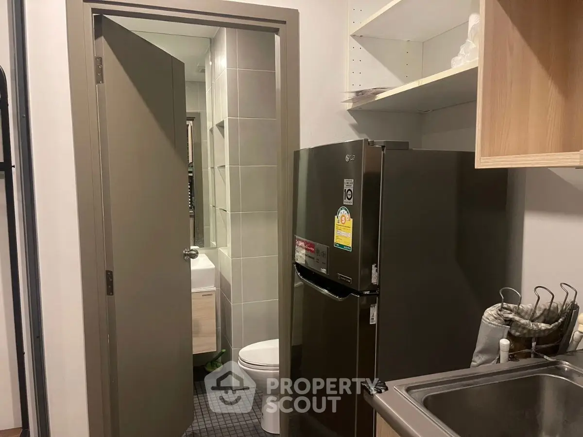 Compact kitchen with stainless steel sink and adjacent bathroom