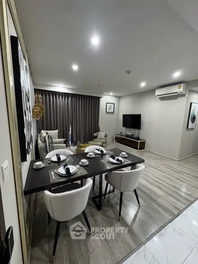 Modern living room with dining area, stylish decor, and sleek flooring in a contemporary apartment.